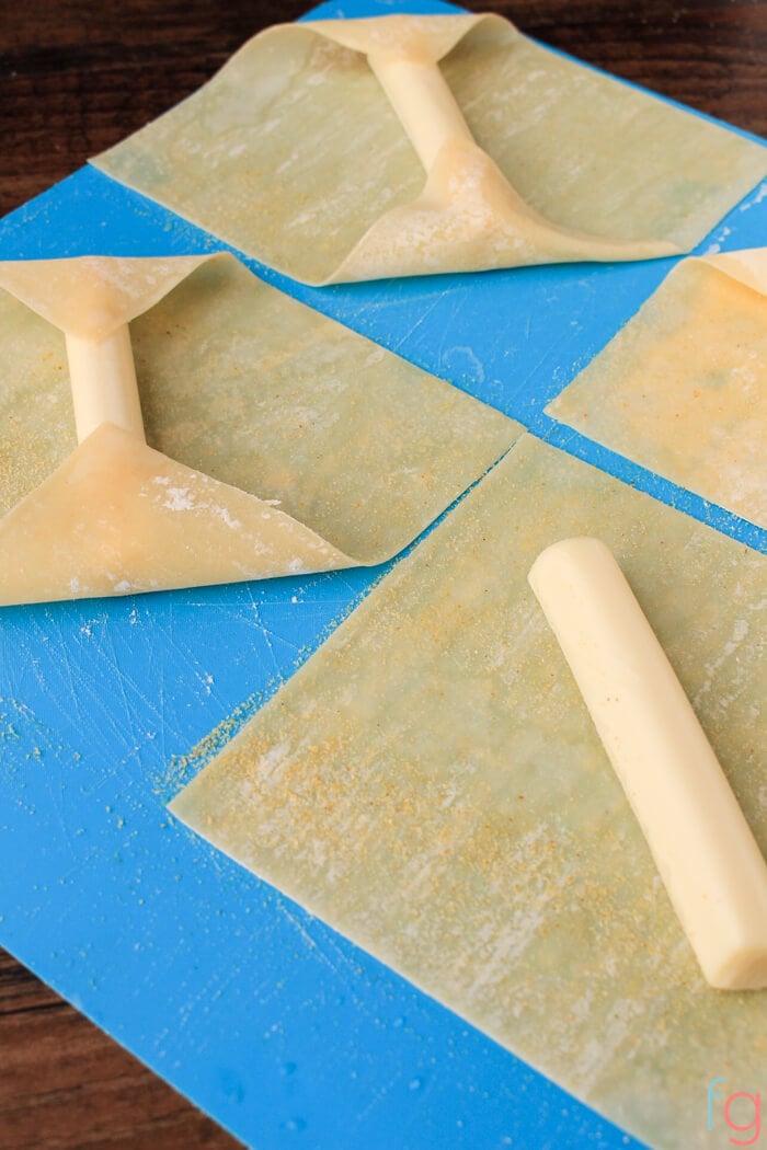 Wrapping mozarella in eggroll wrappers.