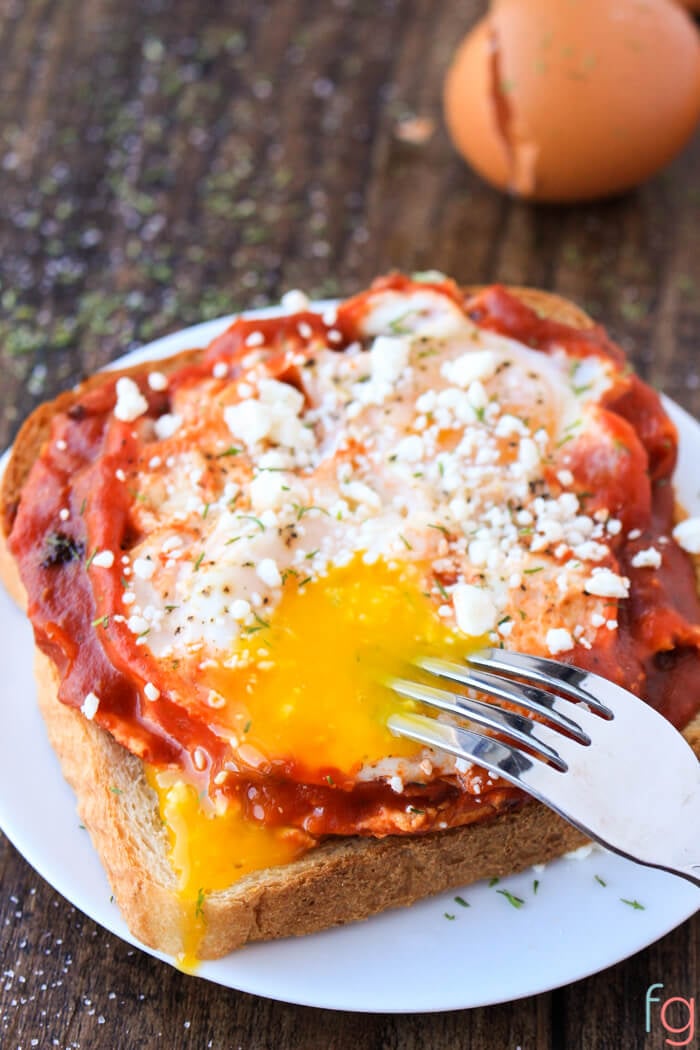 Egg toast pizza on a white plate.