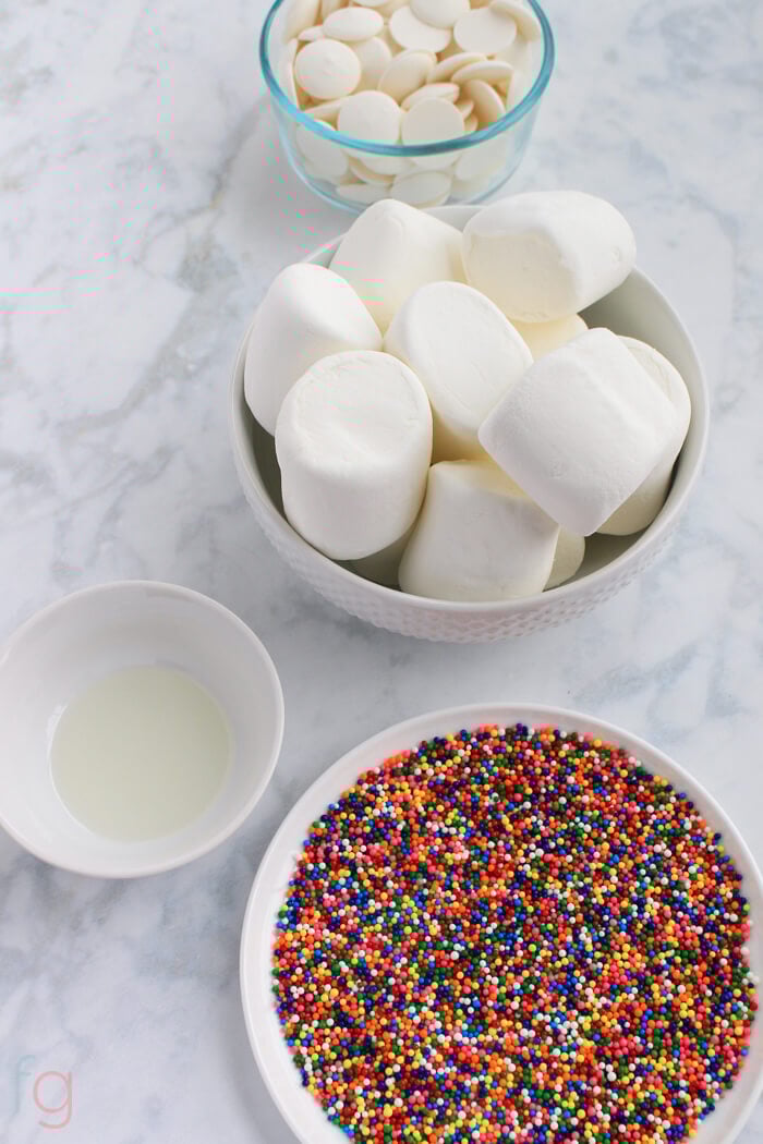 Top view of ingredients for sprinkle marshmallow pops.