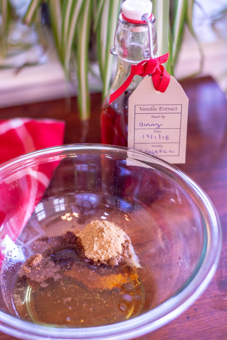 Glass bowl with all the wet ingredients, spices, and Homemade vanilla extract needed for the gingerbread granola.