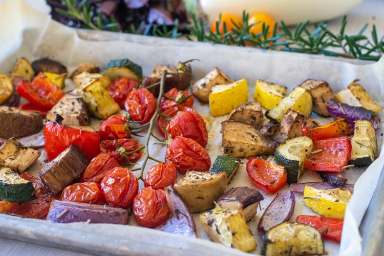 Sheet pan with roasted veggies after cooking in the oven.