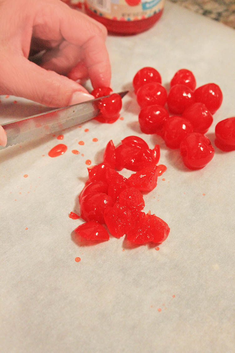 Slicing maraschino cherries for the batter. Showing hands and a knife cutting the cherries.