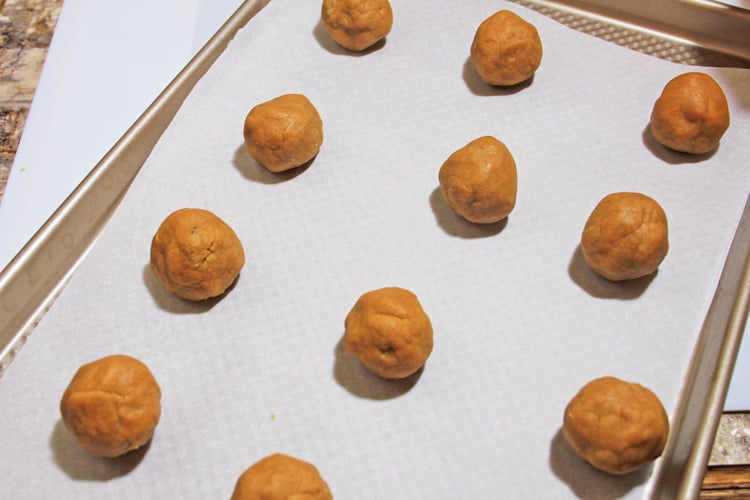 sunflower seed dough rolled into balls and arranged on a cookie sheet ready for baking.