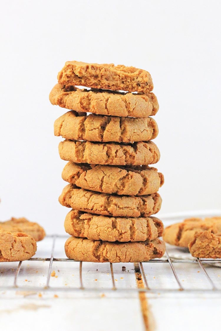 Tall stack of sunflower seed cookies on a wire cooling rack.