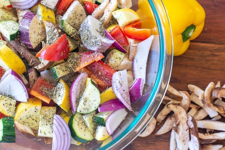 Top down view of bowl of mediterranean veggies with seasoning sprinkled on top.