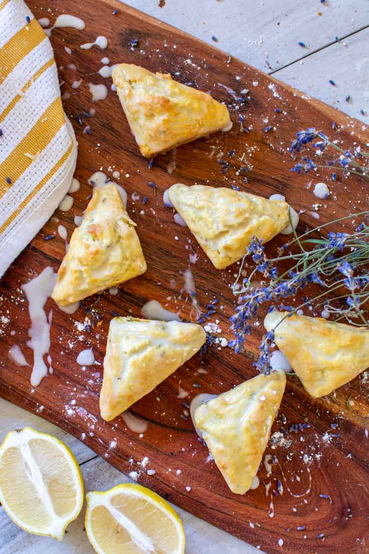 top down view of cutting board with scones, lemons an lavender and plenty of icing.
