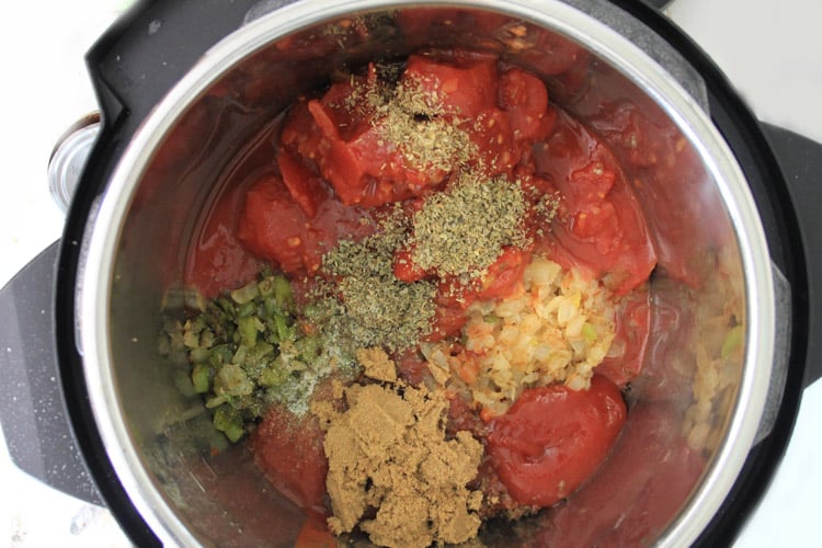 Adding all remaining ingredients to  the pot including brown sugar and herbs.