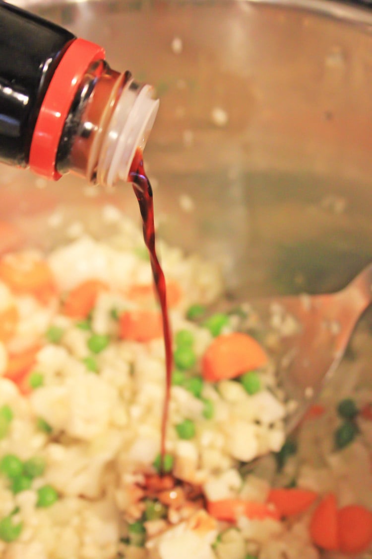 Adding soy sauce to the fried rice.