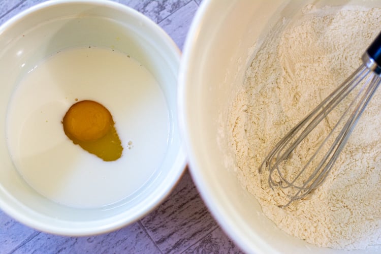 two bowls. One filled with milk and eggs, and one filled with a flout mixture for coating the chicken livers.