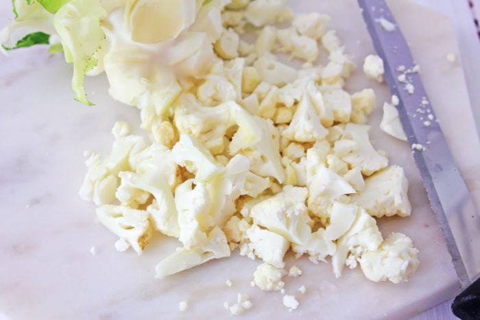 cauliflower florets on a cutting board.