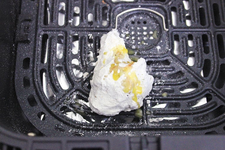 one coated chicken wing in the air fryer.