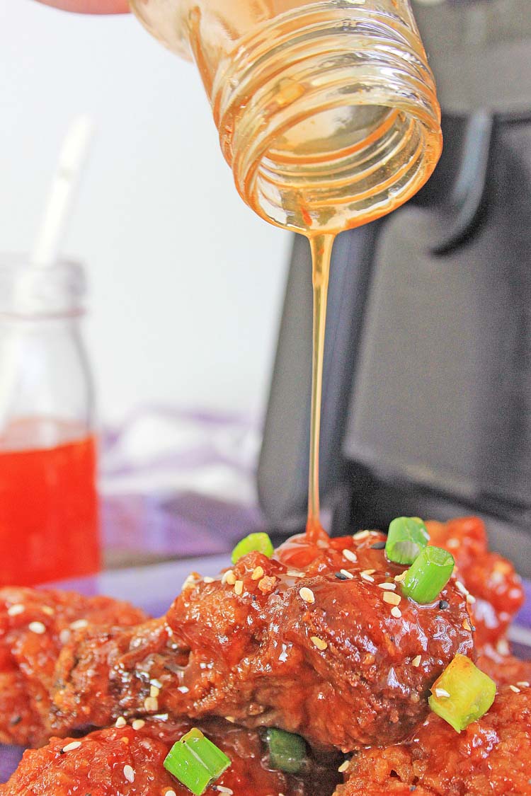 pouring the last bit of the sauce out of the jar and on to the chicken wings.