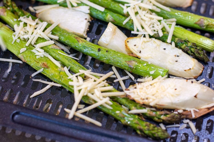 after roasting, the asparagus is quickly topped with parmesan.