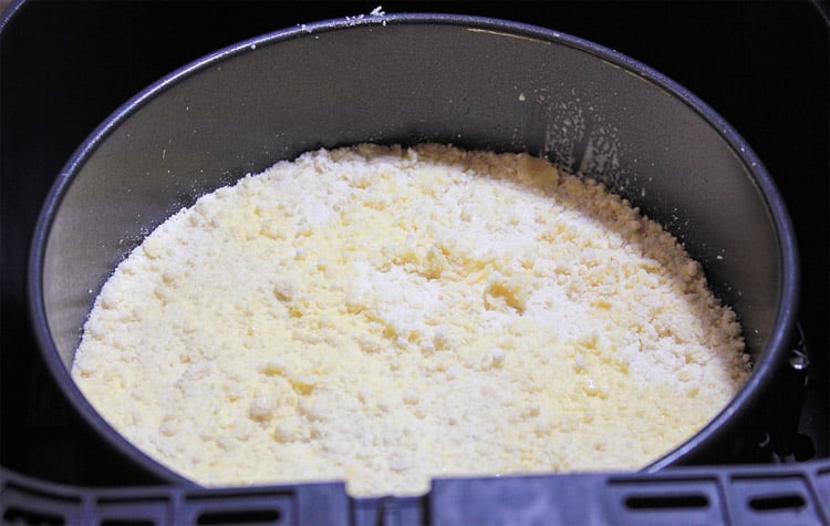 the formed cookie crust of the cheesecake in a springform pan in the air fryer.