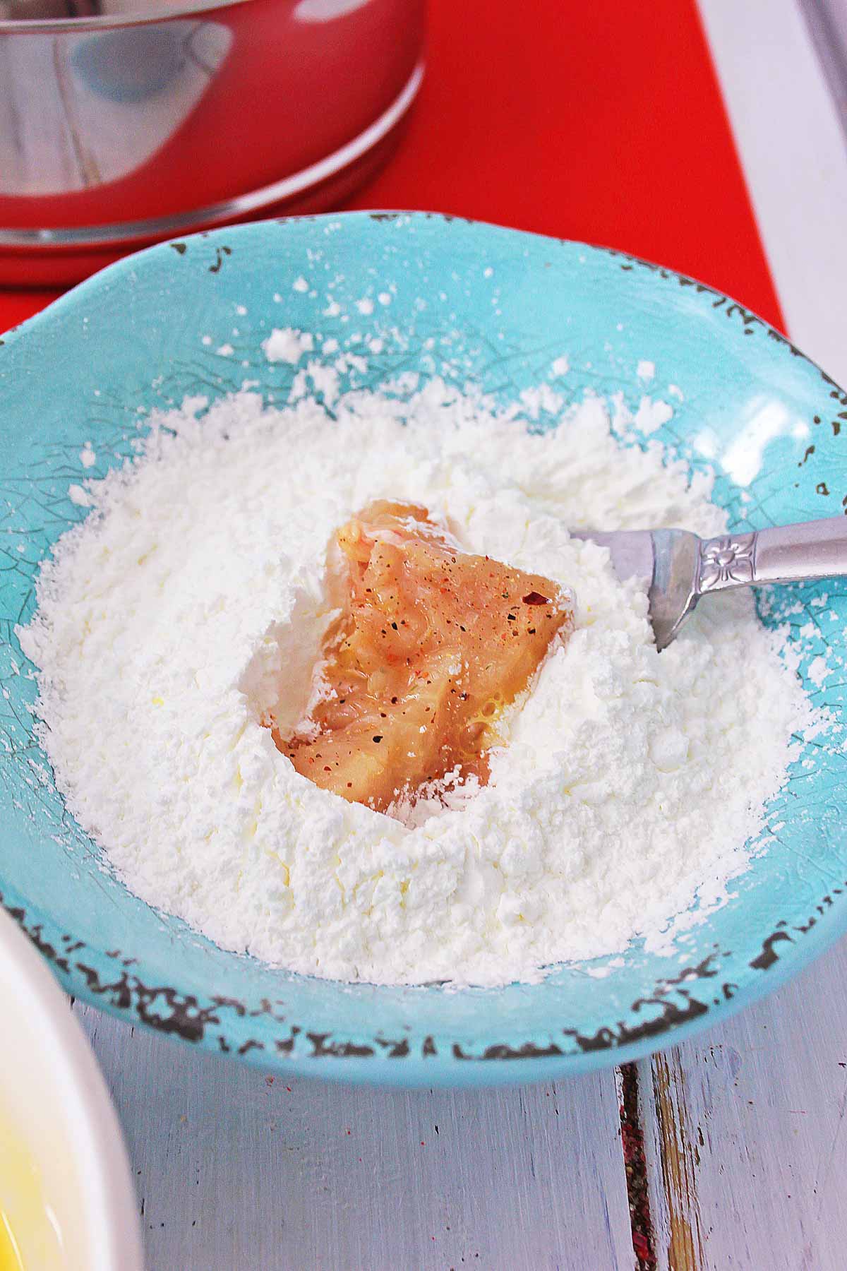 adding the chicken to corn starch.
