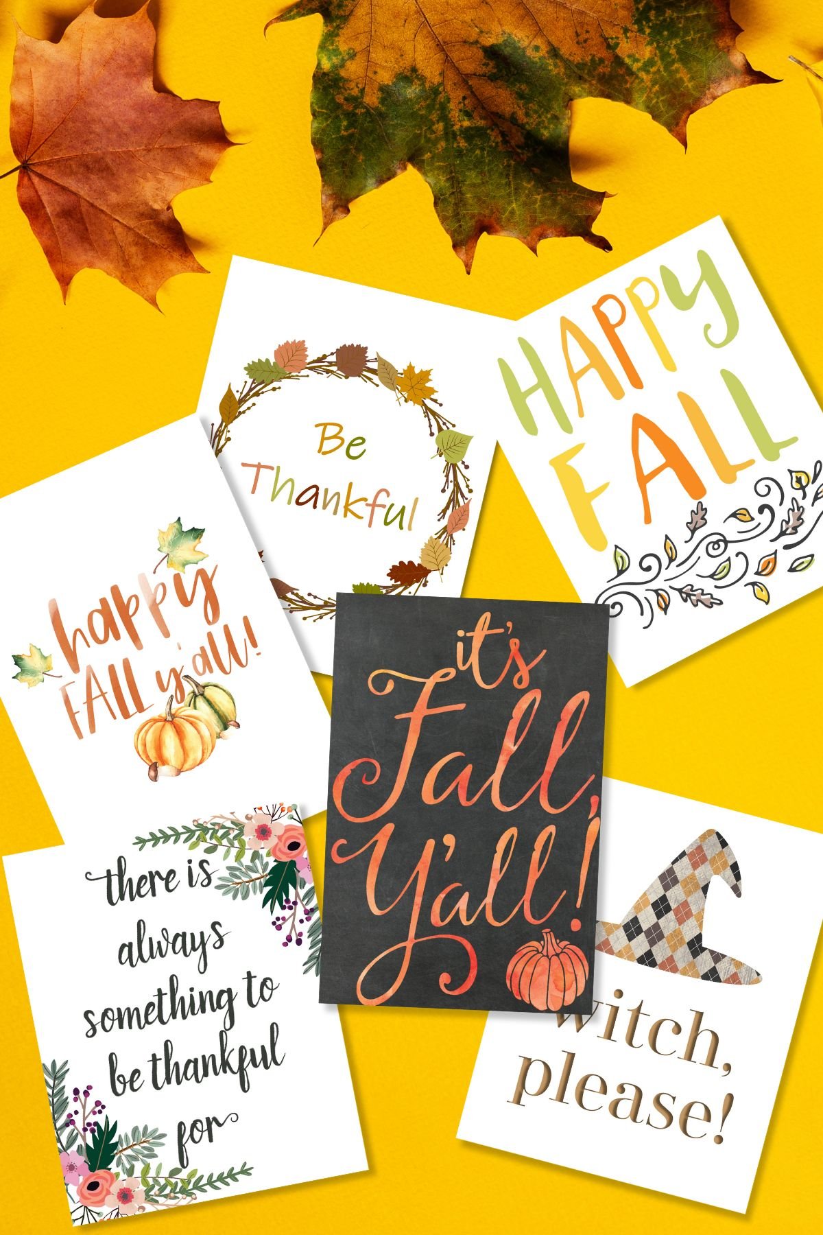 Free printable autumn wall art on a yellow surface next to fall leaves.