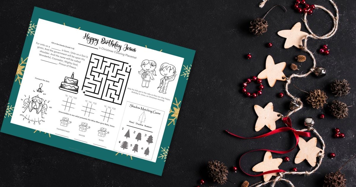 free printable Happy Birthday Jesus placemat on a black table next to holiday decorations.