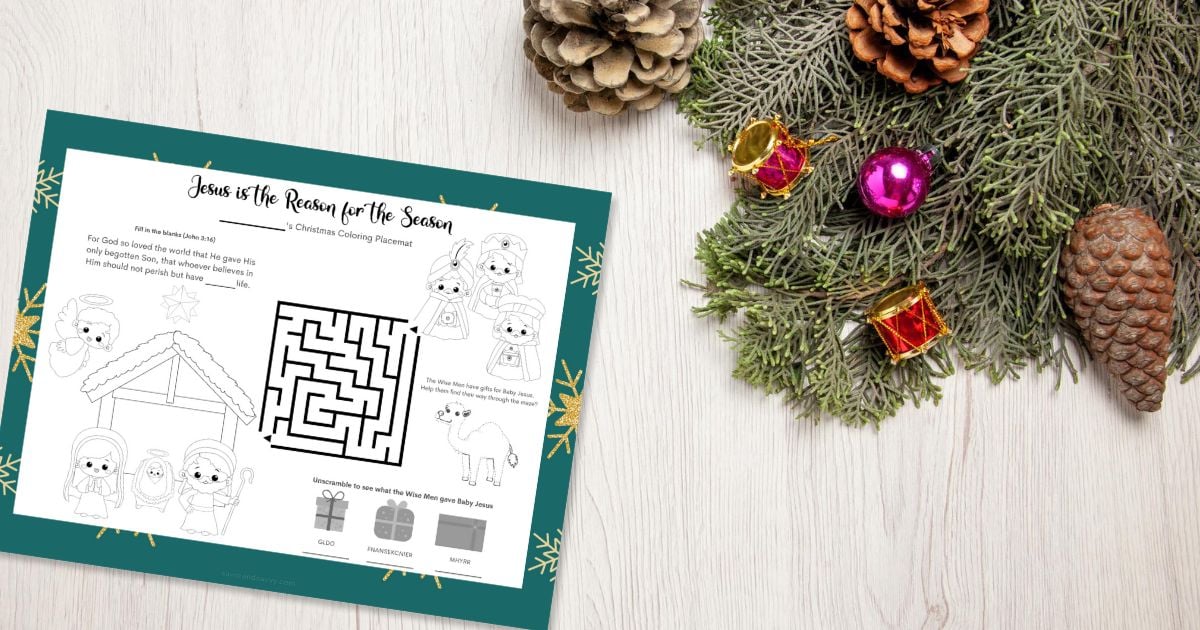 A mixed activity Christmas printable placemat on a wooden table next to Christmas decor.