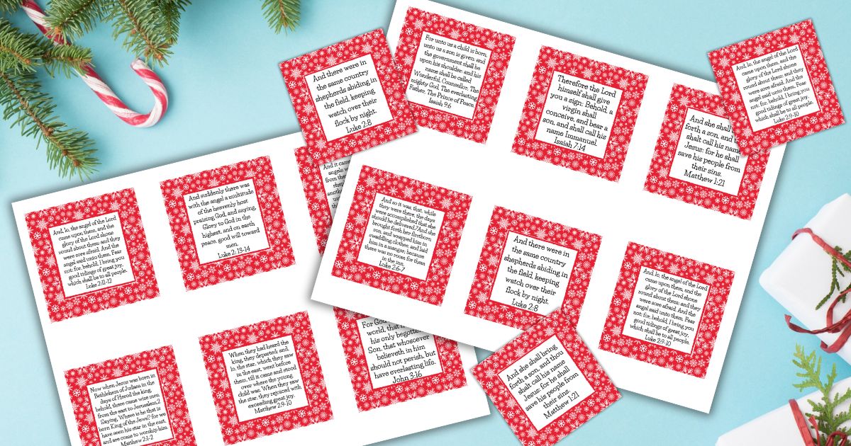 Free printable Bible verse cards for Christmas on a blue surface next to Christmas gifts and decor.