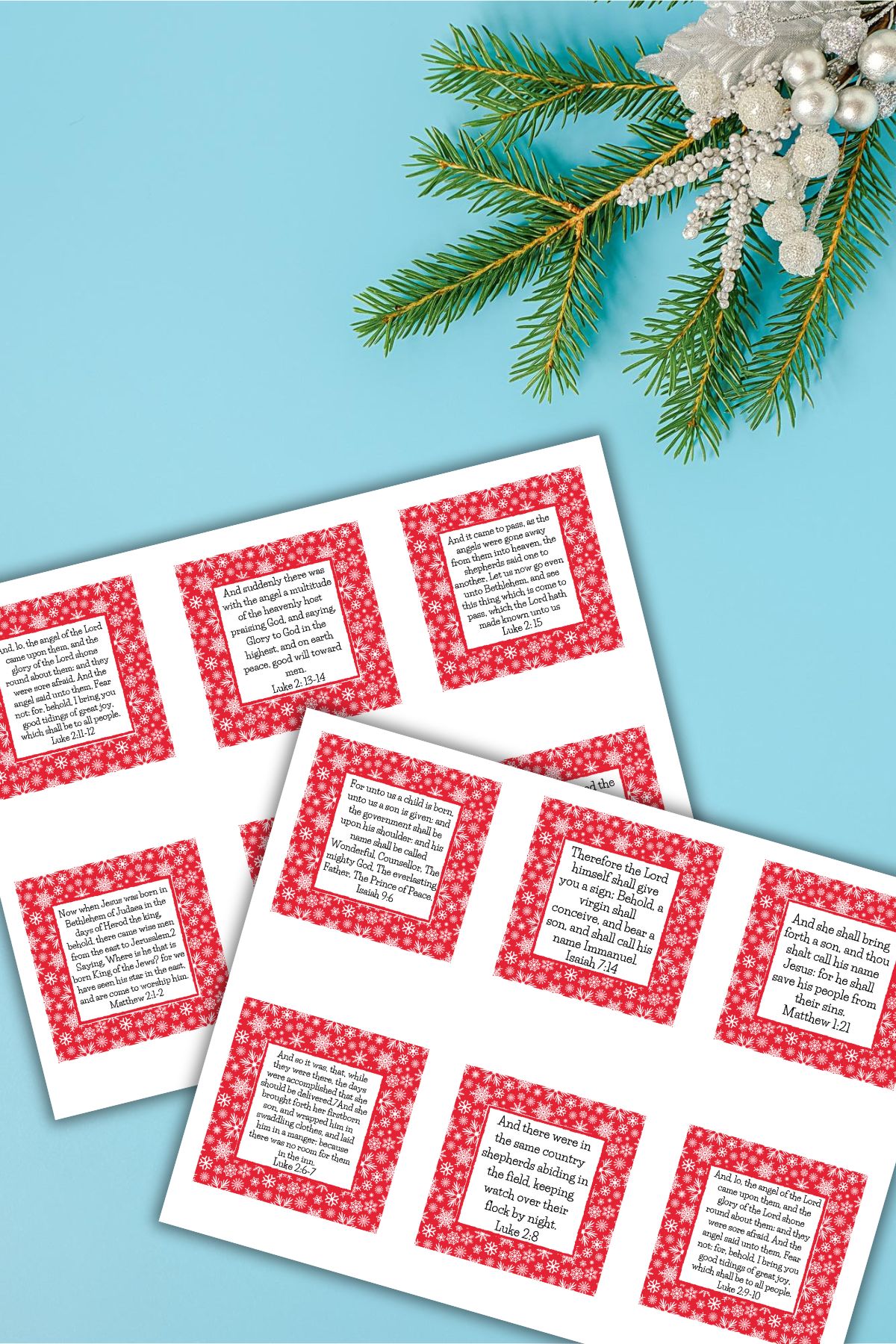 Two pages of Free Printable Scripture Cards For Christmas on a blue background next to winter decor.