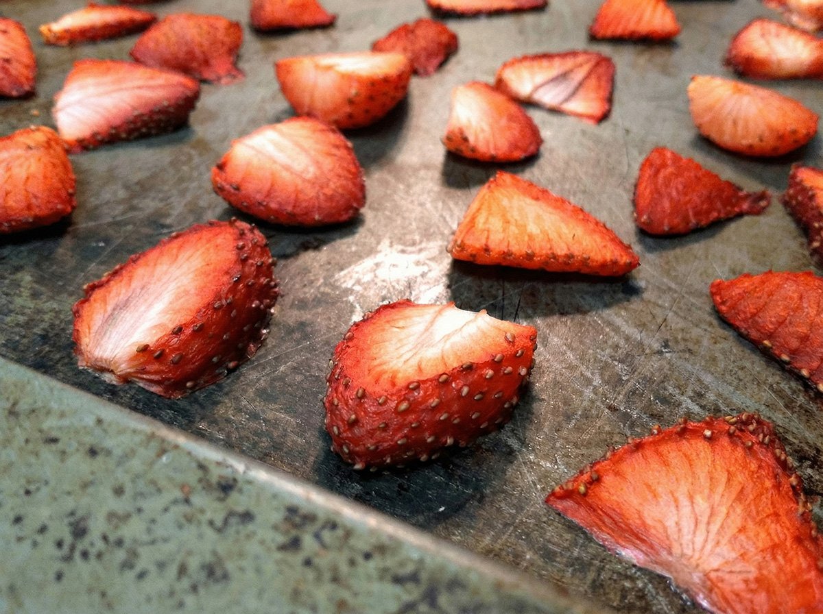 Sliced strawberries on a sheet pan, partially dehydrated in the oven for 2 hours.