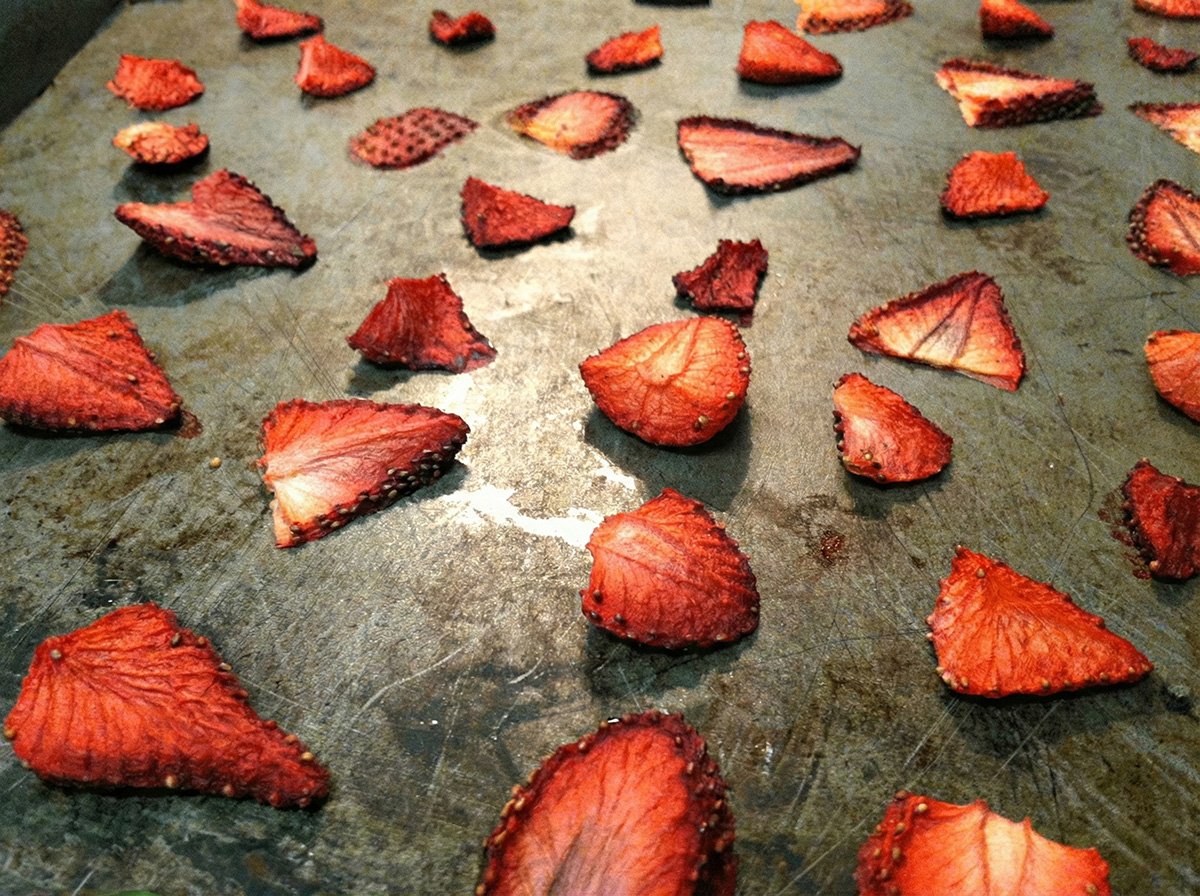 Sliced strawberries on a sheet pan after 3 hours of drying in the oven.