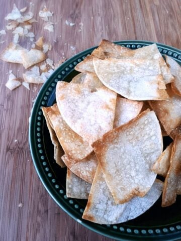 Top view of homemade baked tortilla chips in a bowl.
