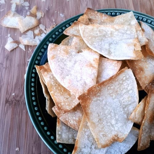 Top view of homemade baked tortilla chips in a bowl.