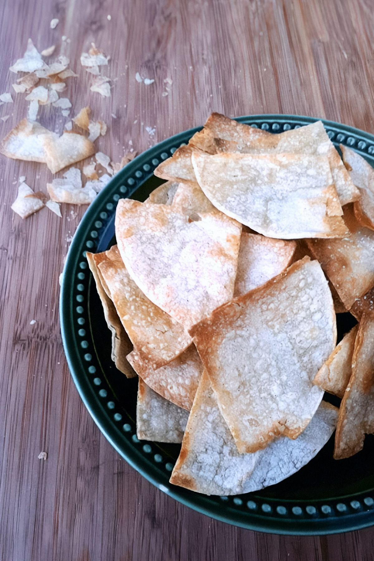 Top view of homemade baked tortilla chips in a bowl.