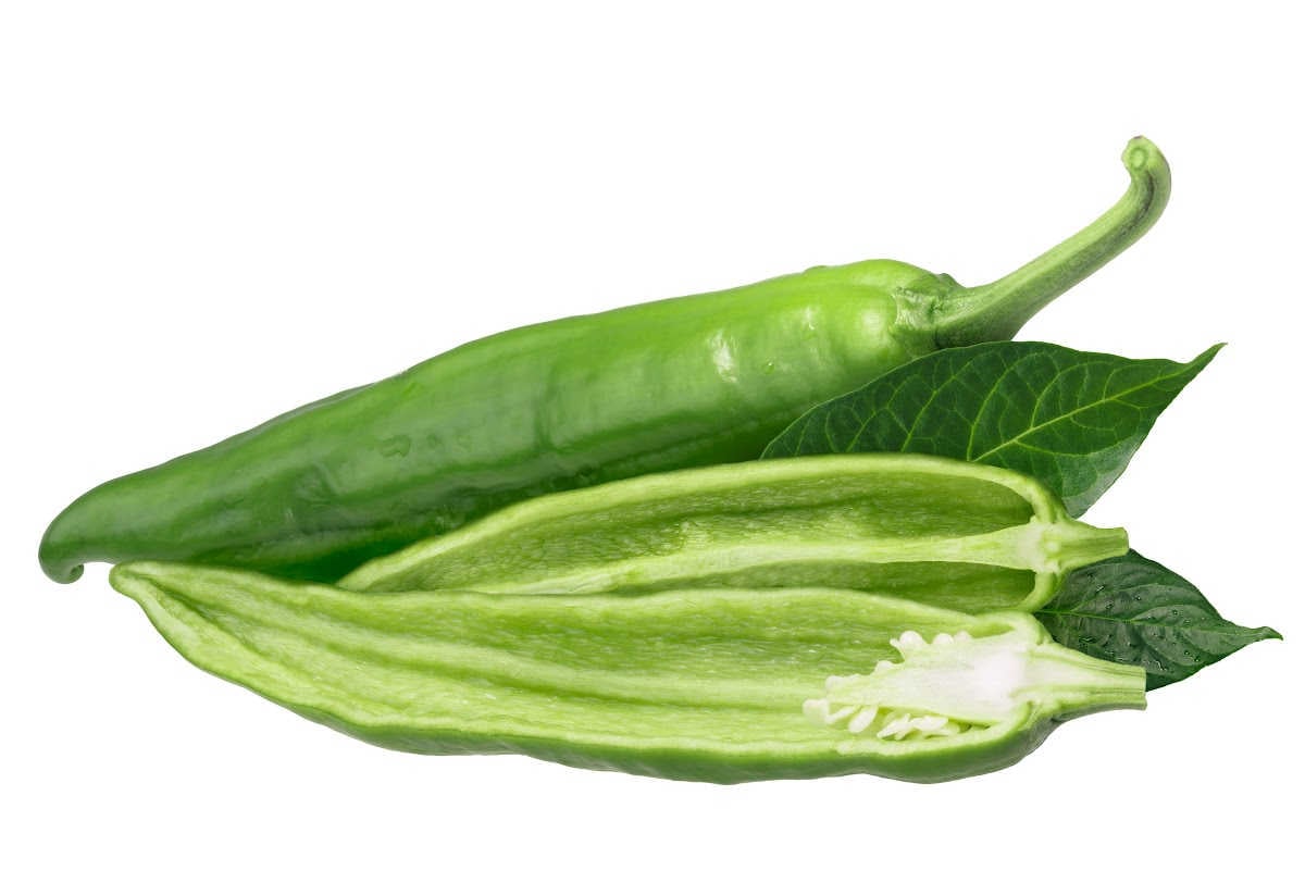 Anaheim peppers on a white background with one cut open.