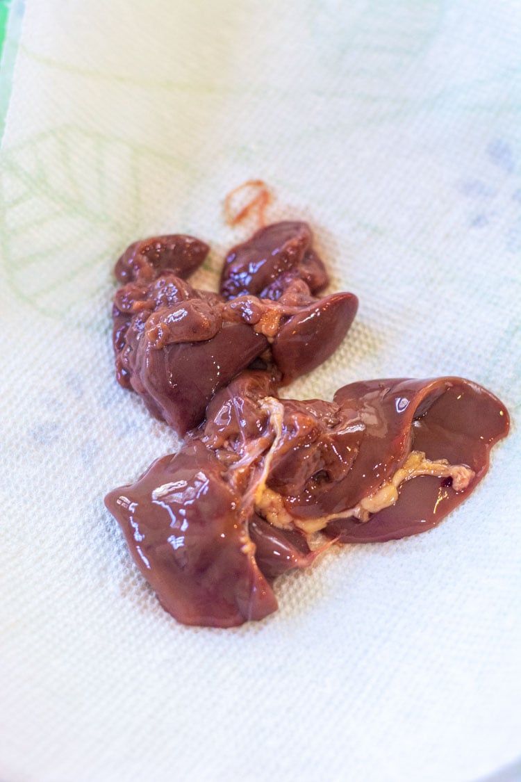 raw chicken livers draining on a paper towel.