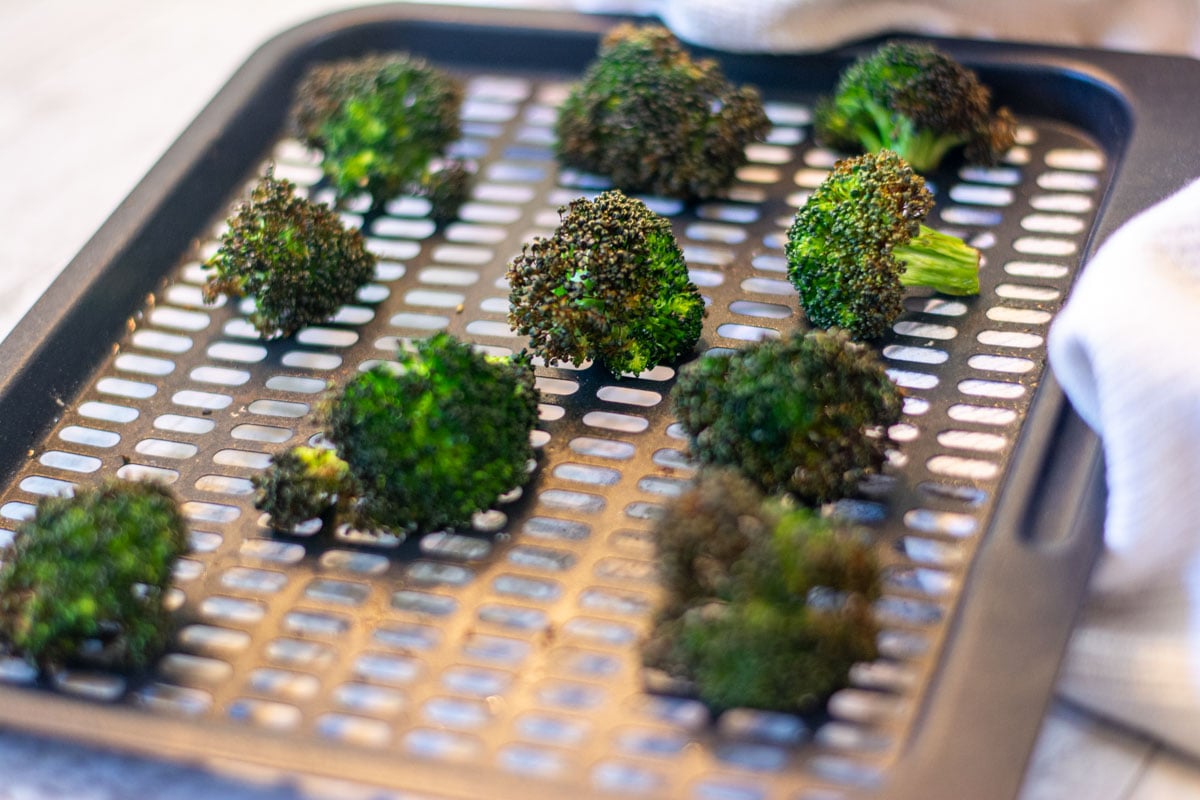 Air fryer roasted broccoli with garlic on the air fryer tray.
