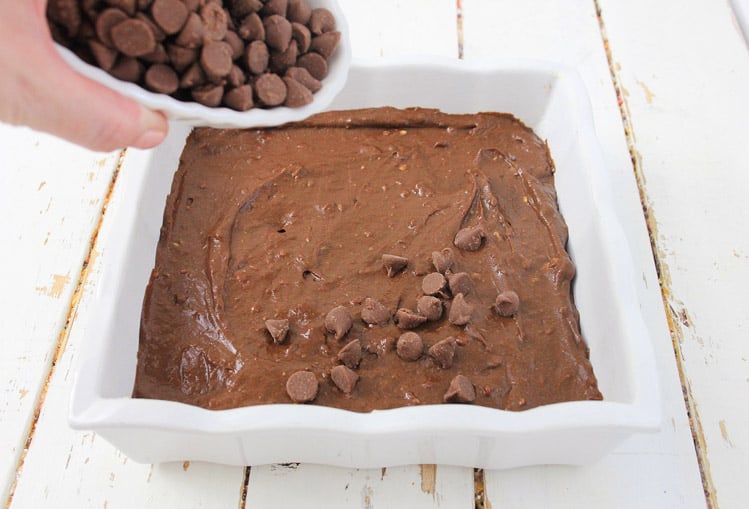 topping the chocolate avocado brownie batter with chocolate chips before baking.
