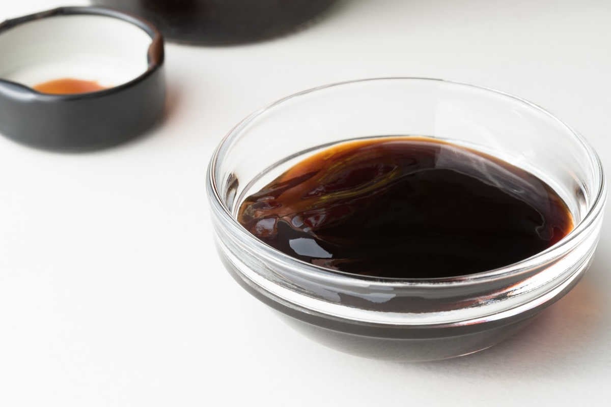 glass bowl with oyster sauce and the lid of the bottle.