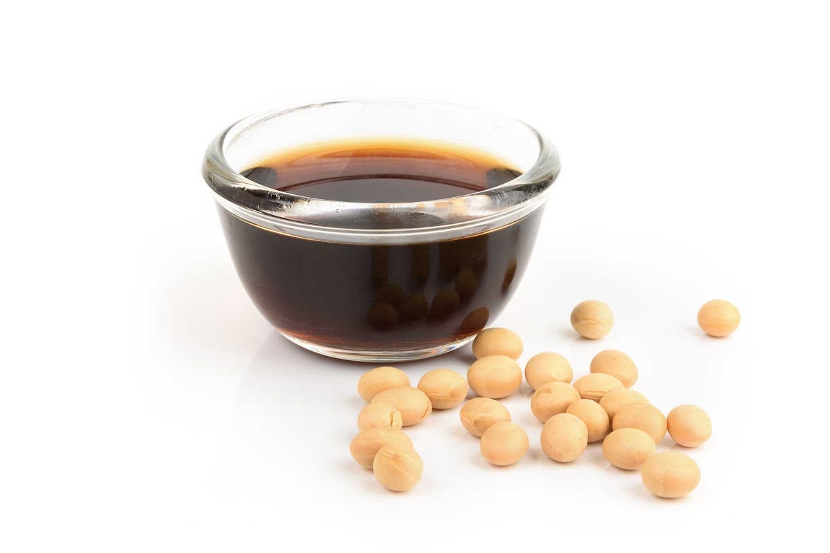 glass bowl filled with soy sauce and beans in the foreground.