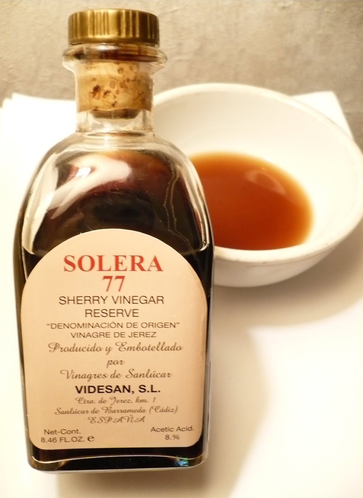 Sherry vinegar in bottle and white ceramic bowl.