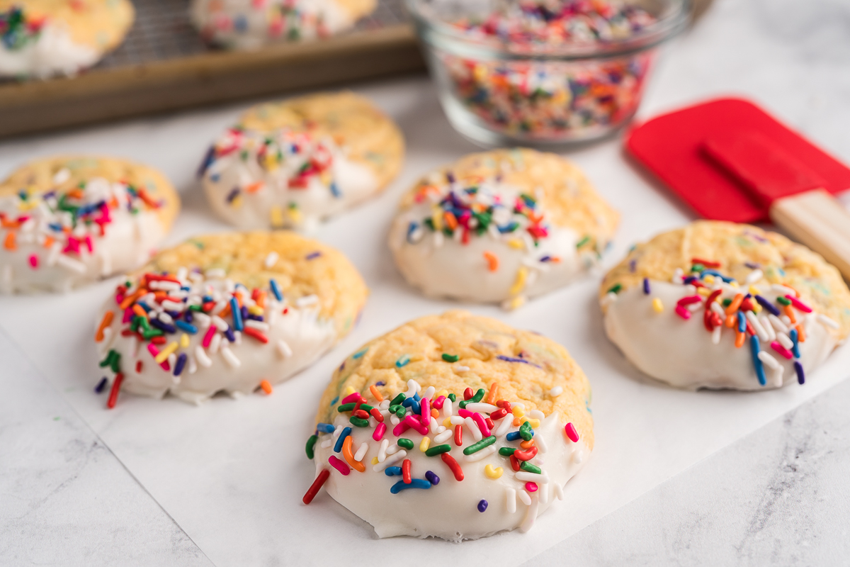 Close up of funfetti cookies with frosting next to spatula.