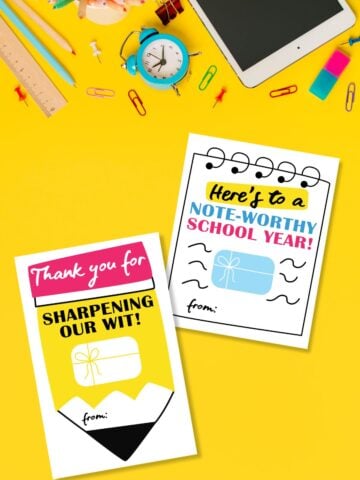 Top view of free printable back to school gift card holders for teachers and kids on yellow background next to alarm clock and school supplies.