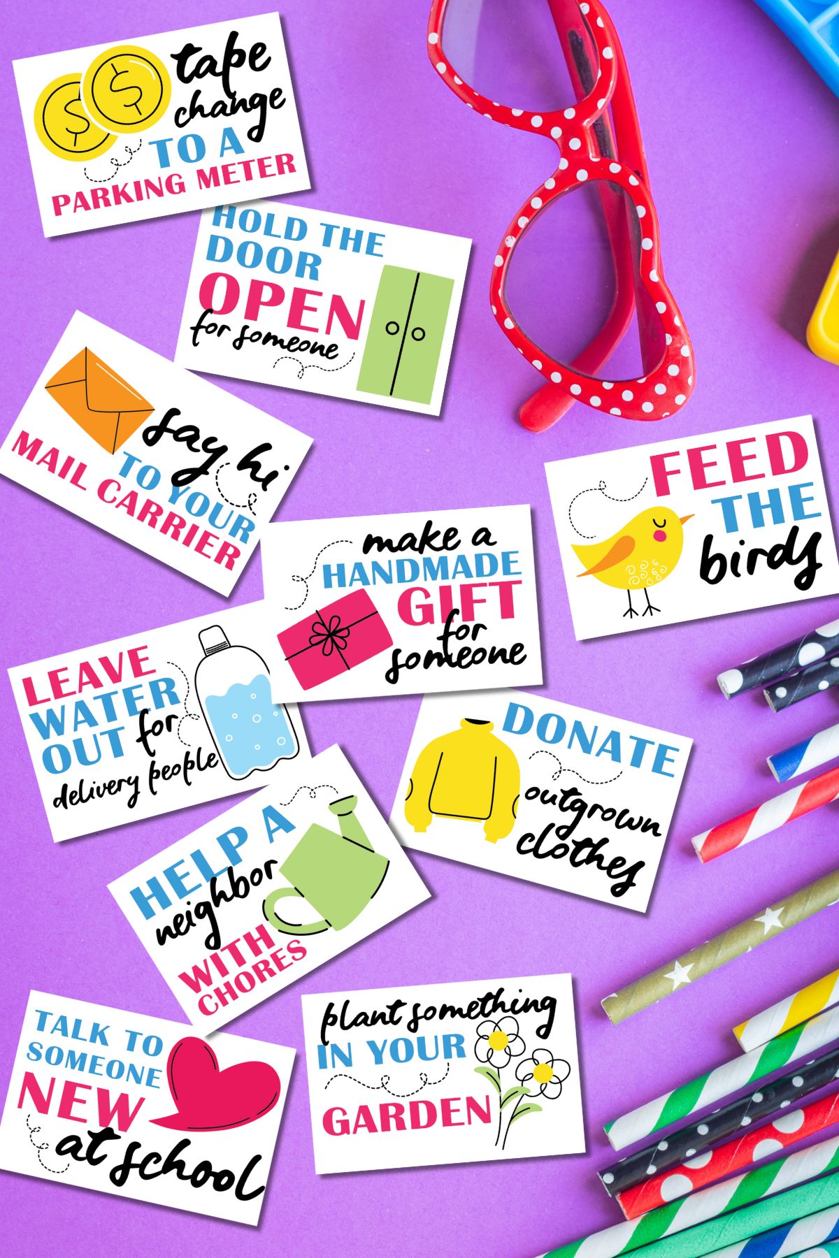 Free printable random acts of kindness cards for kids on purple background next to glasses and school supplies.