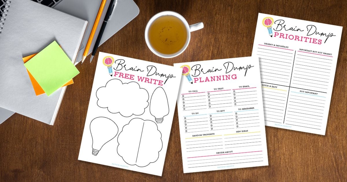 Free printable brain dump worksheets on a wooden tables next to coffee cup and stationery.
