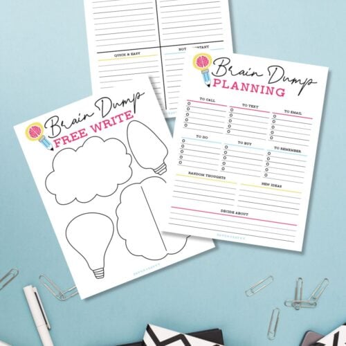 Three free printable brain dump worksheets on a blue surface next to stationery.