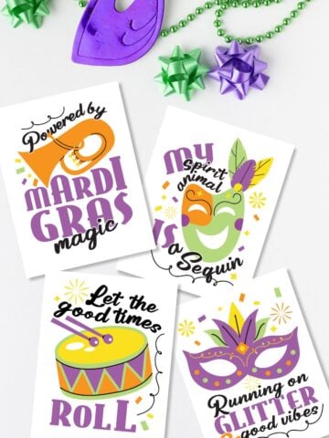 Flat lay with free printable Mardi Gras signs next to beads and masks.