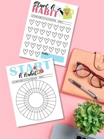 Start A Habit free printable trackers on a pink desk next to laptop and glasses.