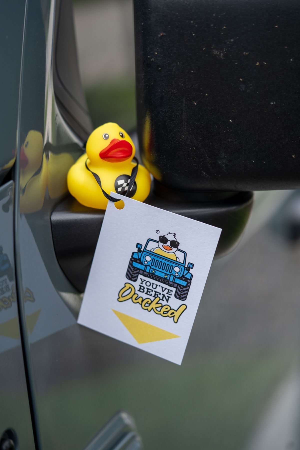 duck on a jeep's side mirror with a printable tag that says you've been ducked.