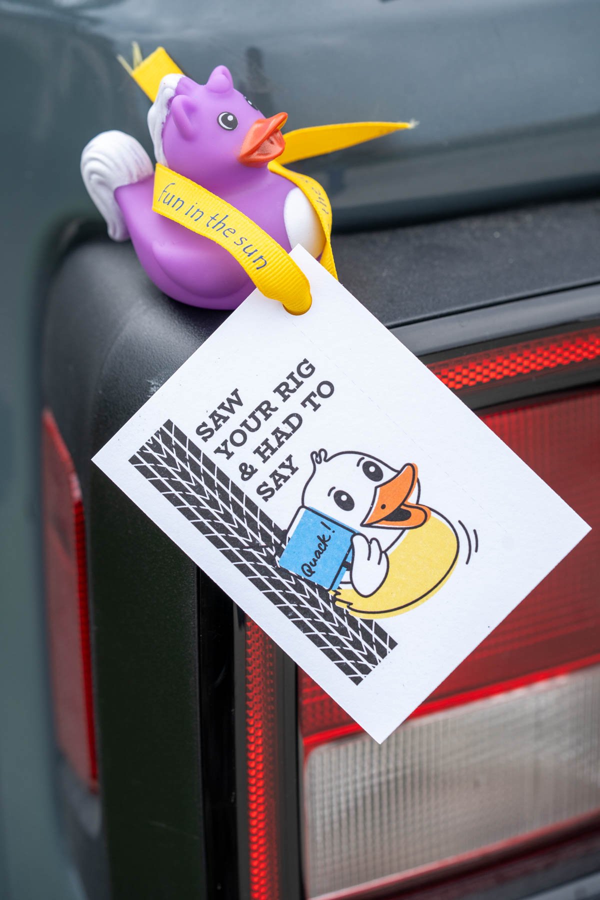 Jeep jeep ducking tag that says "Saw your rig and had to say quack" is attached to a rubber duck, sitting on the stoplight of a jeep.