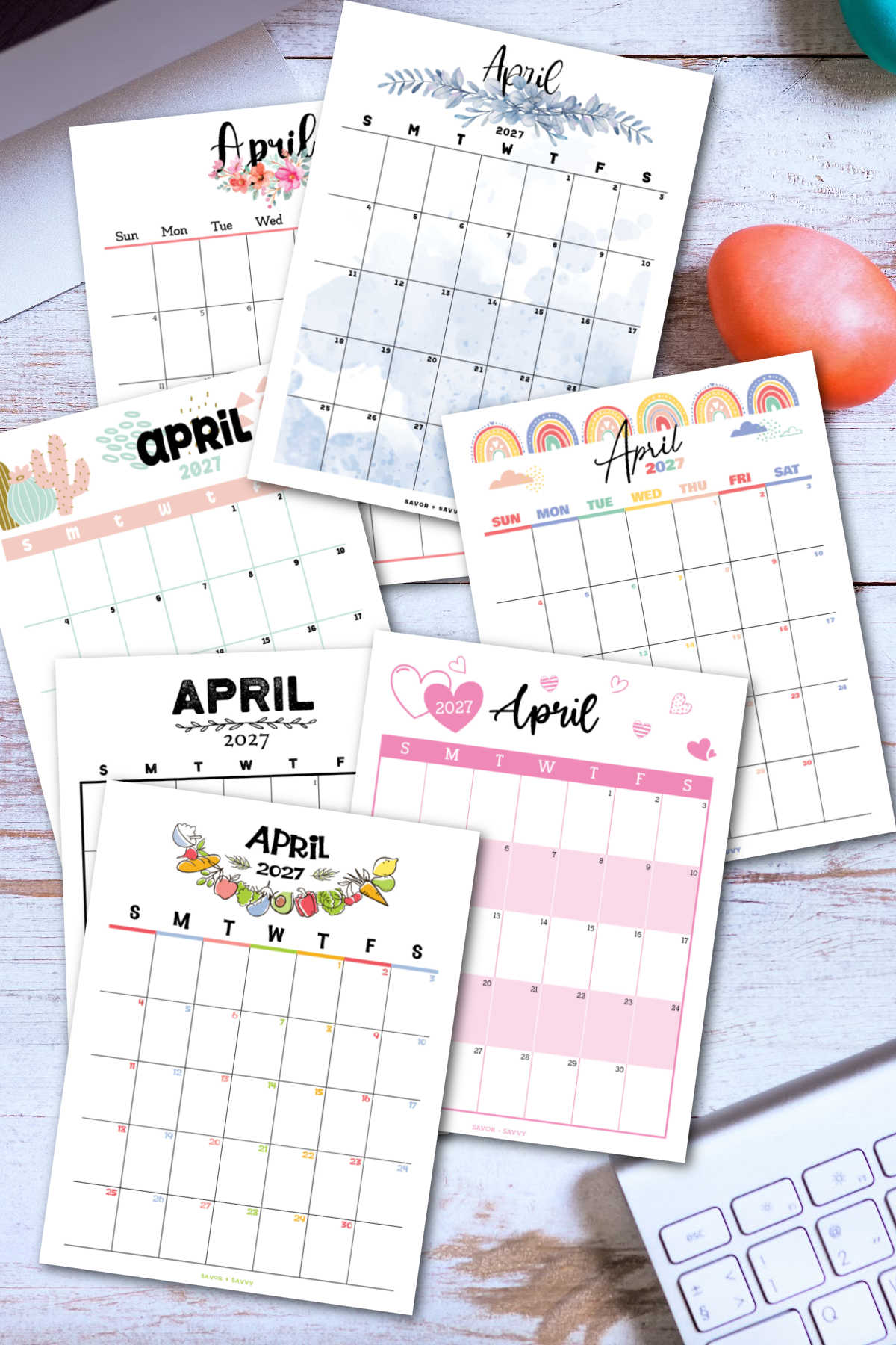 several calendar pages of the free printable April 2027 calendar on a desktop with a keyboard.